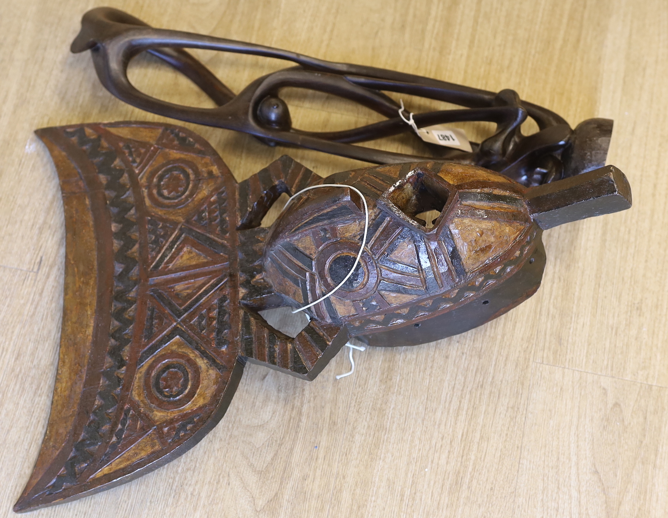 An African carved wood mask and a similar sculpture, 61cm high